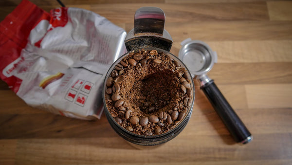 Behälter mit gemahlenem Kaffee und Kaffeebohnen mit Messlöffel