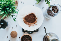 gemahlener Kaffee in Kaffeefilter, Wasserkessel und Kaffeemühle daneben