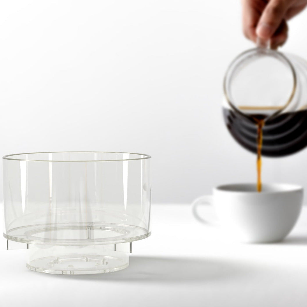 Simplify Handfilter mit Kaffeekanne und Kaffeetasse im Hintergrund