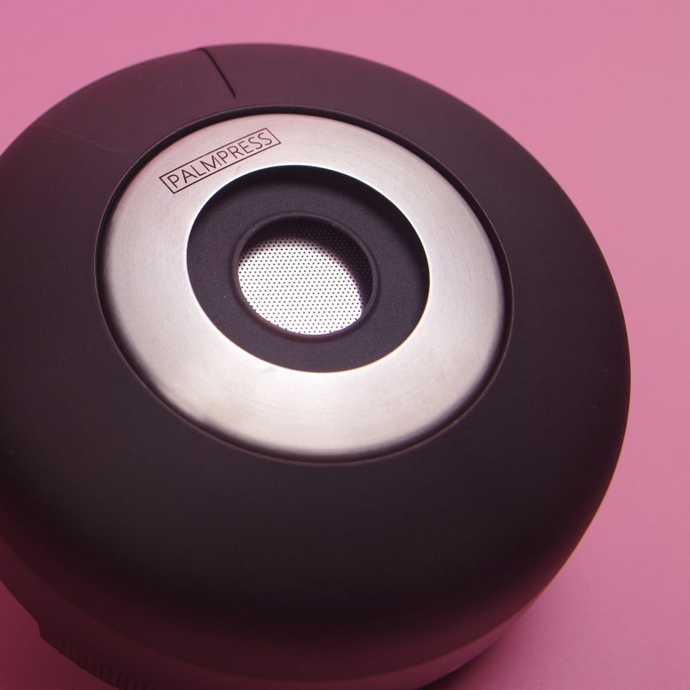 Palmpress Kaffeebereiter Schwarz zusammengeklappt auf Rosa Hintergrund